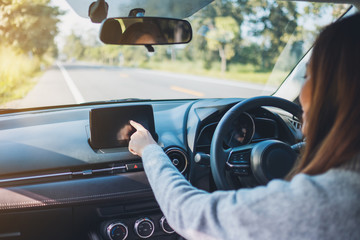 Closeup image a beautiful woman using and pointing finger at navigation screen while driving car