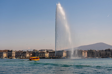 Naklejka na ściany i meble The Geneva Water Fountain, Jet d.Eau, in the city of Geneva. One of the for Geneva typical yellow boats.