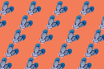Colorful pattern of striped print flip flops isolated on trendy orange background. Summer...