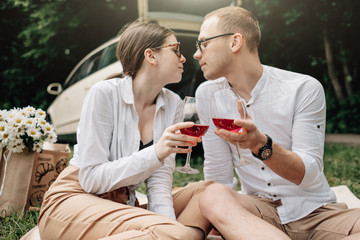Young Happy Couple Dressed Alike in White T-shirt Having Fun Near the Car, Weekend Outside the City, Holidays and Road Trip Concept