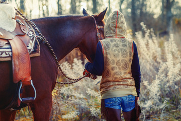 Young beautiful dreadded girl outdoors with her horse.