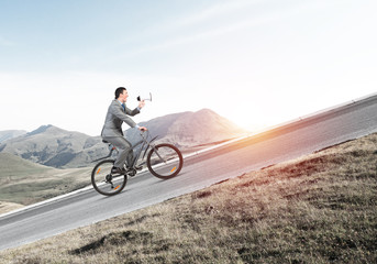 Businessman with megaphone in hand on bike