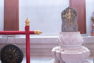 The old stone blocks in the temple were covered with gold leaf, near the back of the bell hung on a red wooden post.