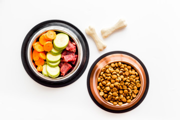 Ingredients of dry feed for dogs - meat, vegetables - near bones on white background top view