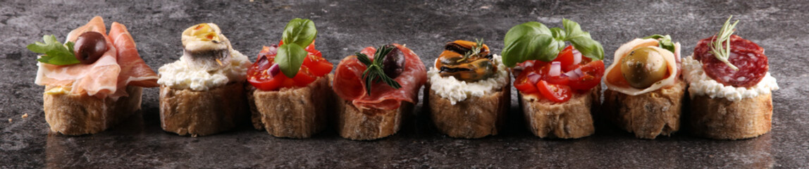 Appetizers table with italian antipasti snacks and wine in glasses. Brushetta or authentic traditional spanish tapas set, cheese variety