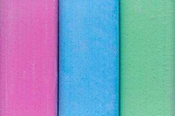 Background from colorful crayons. Colored chalk. Blue, green and pink children’s crayon in macro...
