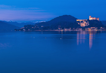 framed by the snow-capped Prealps, the Angera fortress dominates Lake Maggiore in the blue hour