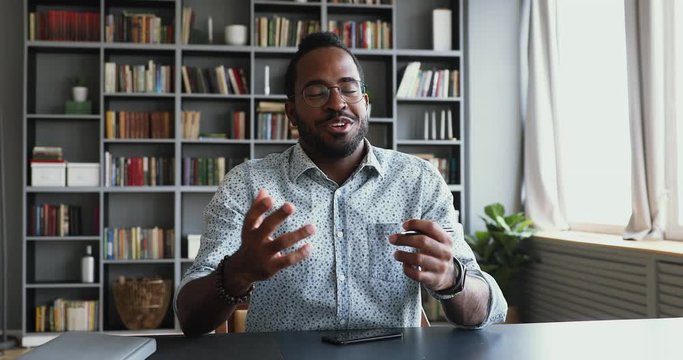 Confident african businessman look at webcam conference calling in office