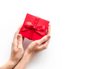 Give a gift on Valentine's Day. Women hand hold beautiful red present box on white background top-down copy space