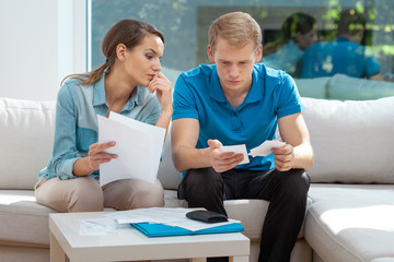 Young couple doing paperwork together, planning family budget, calculating domestic expenses