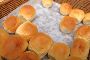 Lots of fresh bread in a basket on a table