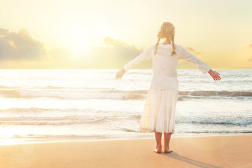 Fototapeta na wymiar Happy Blonde Girl on beach enjoying serene ocean nature during travel holidays vacation outdoors