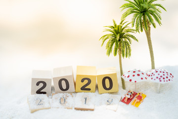 Wooden word number 2019 - 2020 on sand beach and copy space for text using as background business travel, happy new year concept.