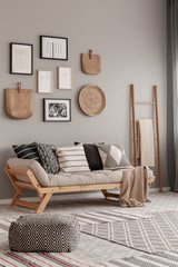 Beige scandinavian settee with patterned pillows in stylish living room interior - obrazy, fototapety, plakaty