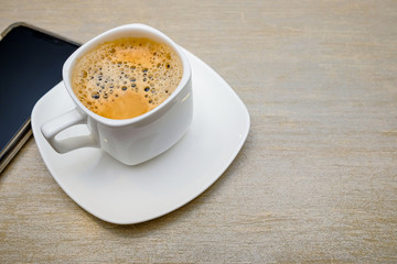 A cup of coffee  with milk served on the table