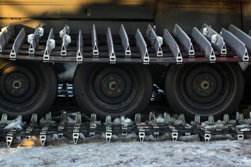 Caterpillar spikes on snowmobile in ski resort. Machine wheels with spikes for winter off road,...
