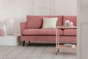 Stylish coffee table with kinck knacks in front of elegant couch with pillows