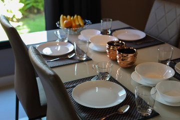 dish ware sets arrange on breakfast table in the morning inside eating room of modern home interior