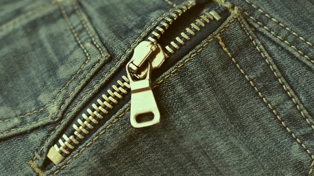 Close-up of zipper of old blue jeans. Classic Metal zipper on pocket. Old Shabby Jeans. Selective focus.