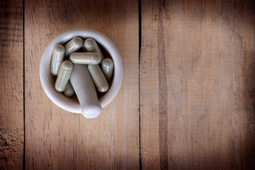 Alternative medicine herb , mortar, laboratory glassware, on a wooden background.