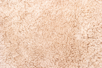 Fototapeta na wymiar The texture of the light beige carpet is a synthetic carpet. Texture closeup. Useful background texture