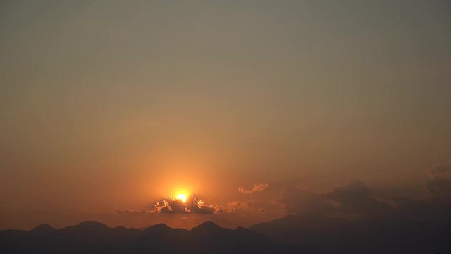 Beautiful sunset landscape. Sun rolling down hiding behind mountains. Black small silhouettes of flying airplanes in sky, night is coming. Timelapse full hd video footage.
