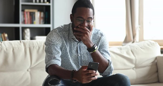 Excited african man hold smartphone feel overjoyed about mobile win