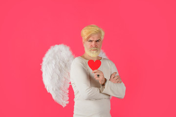 Handsome angel Cupid. Cupid holds valnetine's heart. Valentines Day. Angel man with white wings....