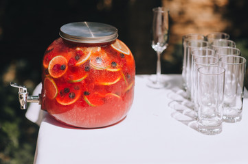 Delicious alcoholic cocktail in a jar of fresh fruits with the addition of grenadine. Wedding reception, banquet. Photography, concept.