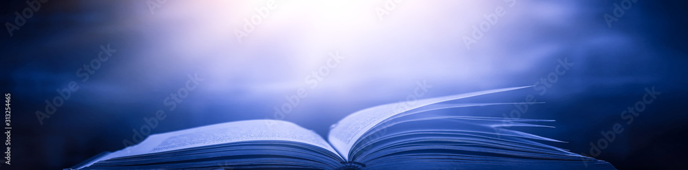 Poster imagine a picture book of an ancient book opened on a wooden table with a sparkling golden backgroun