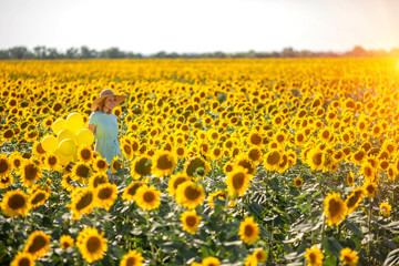 Obraz premium Happy carefree summer girl in a summer sunflower field