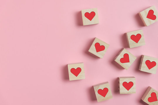 Heart in Wooden cubes on pink background.