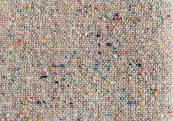 The texture of the costume fabric boucle with colored inclusions