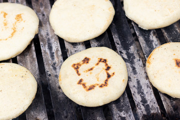 Toasted arepas cooking on the grill