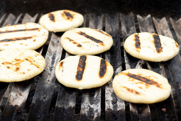 Toasted arepas cooking on the grill