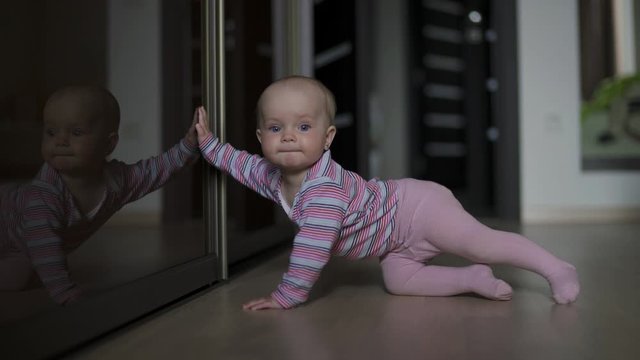 A young child learns to crawl on the floor.