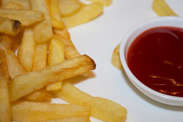 Chips fries and red tomato sauce on a white plate in a cafe. View from above.