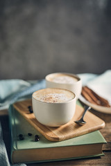 Hot coffee cup and coffee beans on wooden table..