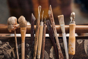 Tools for forming clay on  wooden background..
