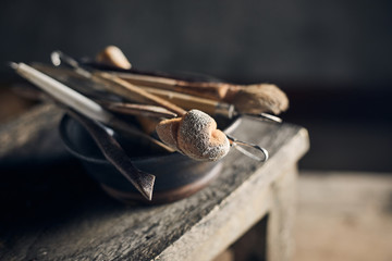 Tools for forming clay on  wooden background..
