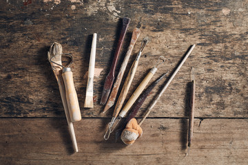 Tools for forming clay on  wooden background..