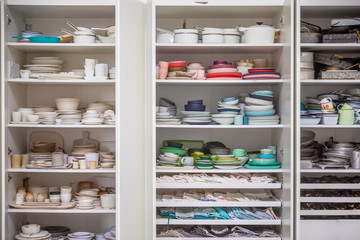 Kitchen cupboard with many plates and bowls