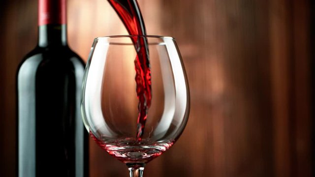 Super slow motion of pouring red wine into glass in detail. Filmed on high speed cinema camera, 1000 fps