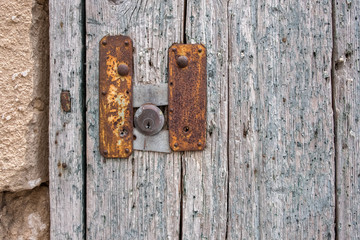 Lock in an old wooden door, rusty metal. Close-up, texture.