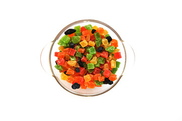 Assorted candied fruits in a glass dish on a white background