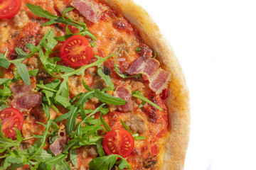 Italian hot pizza with tomato, arugula and pieces of bасon isolated on white background