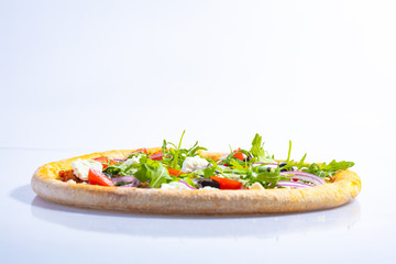 Italian hot pizza with tomato, arugula, cheese Feta, black olives and rings onion isolated on white background