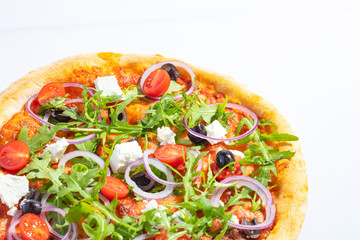 Italian hot pizza with tomato, arugula, cheese Feta, black olives and rings onion isolated on white background