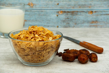 A bowl of healthy cornflakes with homemade breakfast milk, topped with raisins, served in a glass...