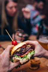 Man holding burger in beer house